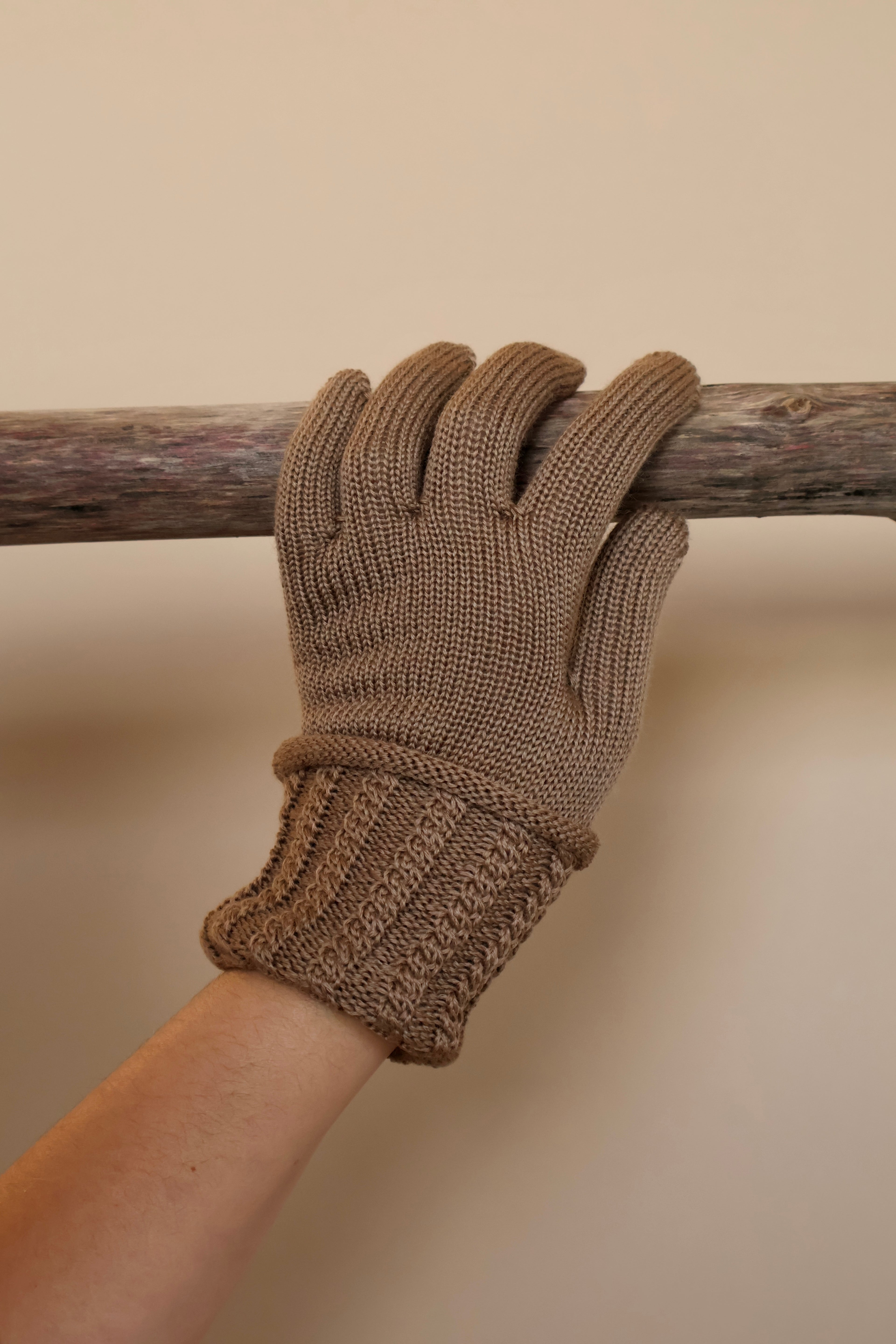 Bruin gebreide handschoen met omgeslagen manchet.