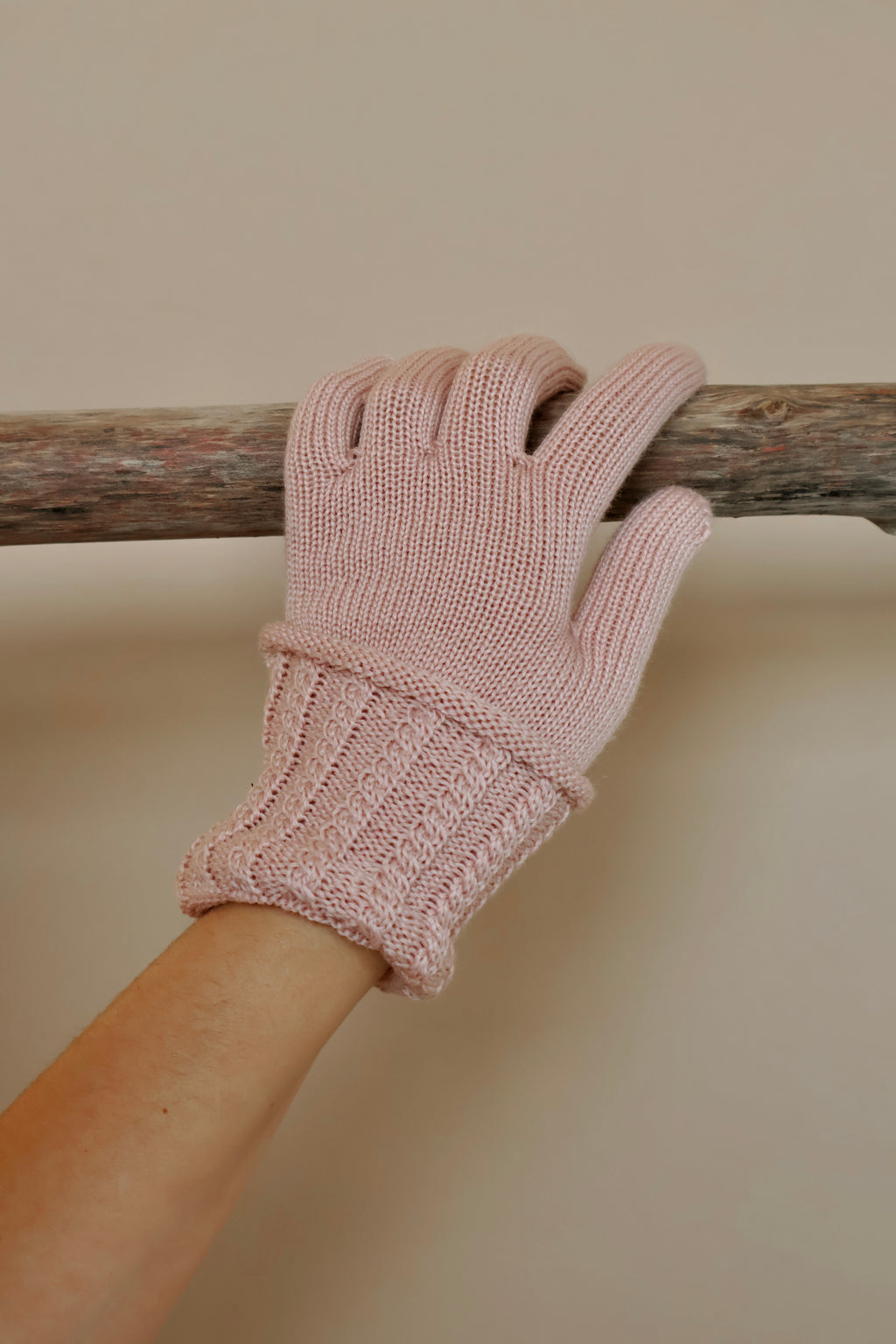 Roze gebreide handschoen met omgeslagen manchet.