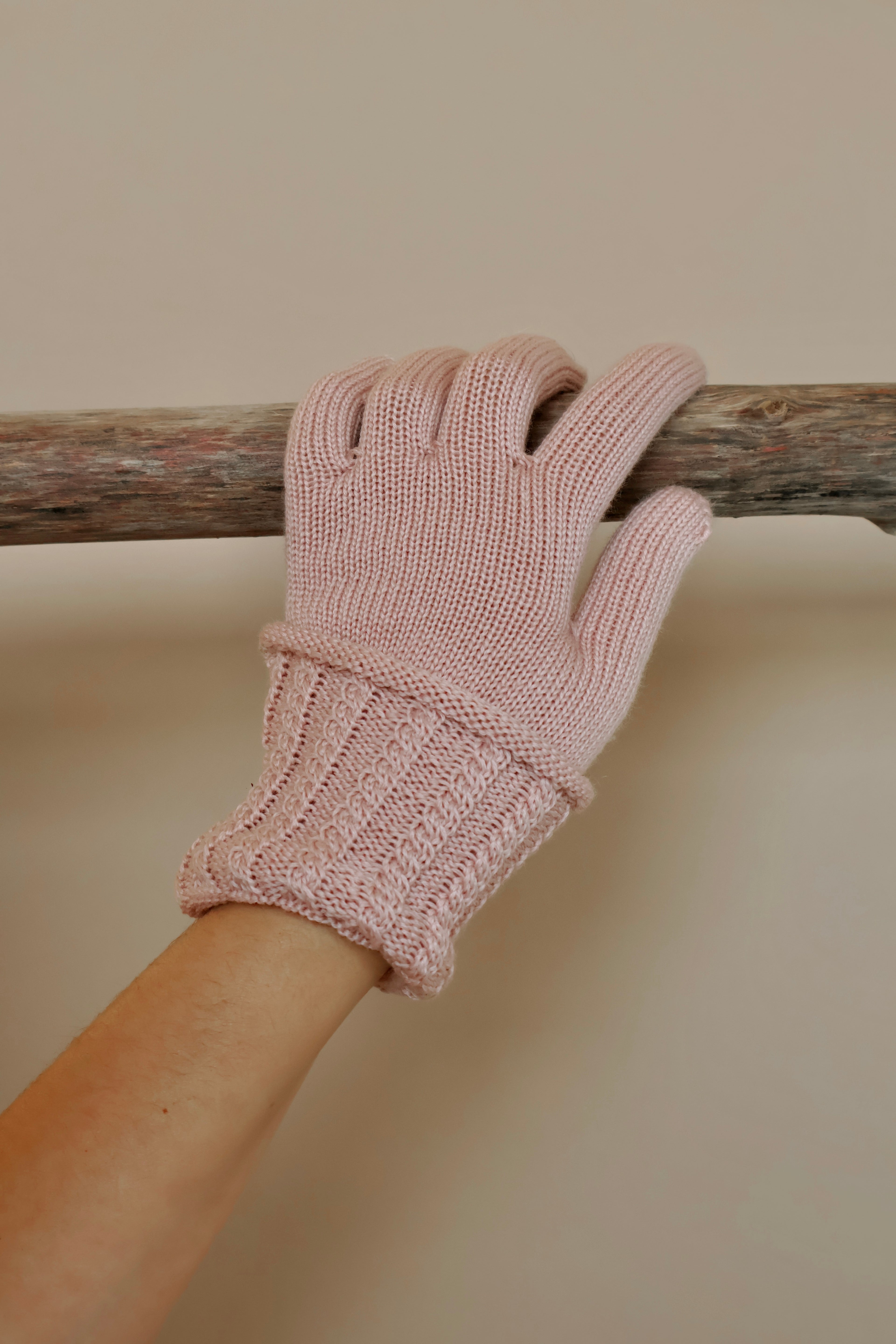 Roze gebreide handschoen met omgeslagen manchet.