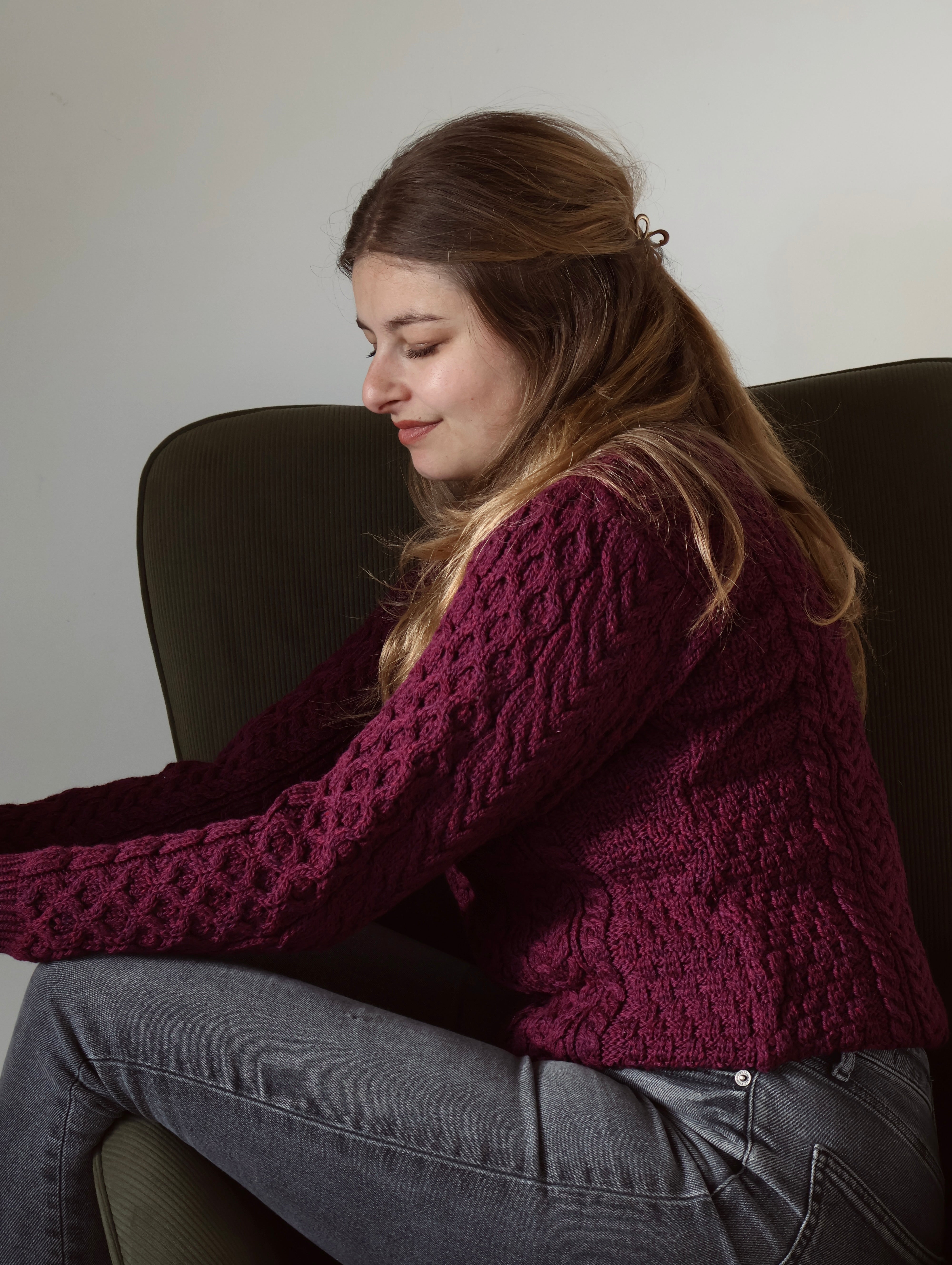 Vrouw met paarse trui, zittend op een stoel