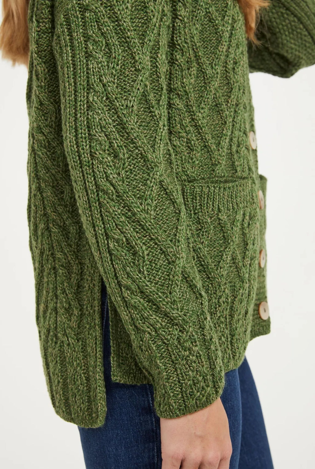 Close up beeld van het zijaanzicht van een groen vest waarin de nadruk ligt op de lengte verschil van het voor en achterpand en de split in de zijnaad