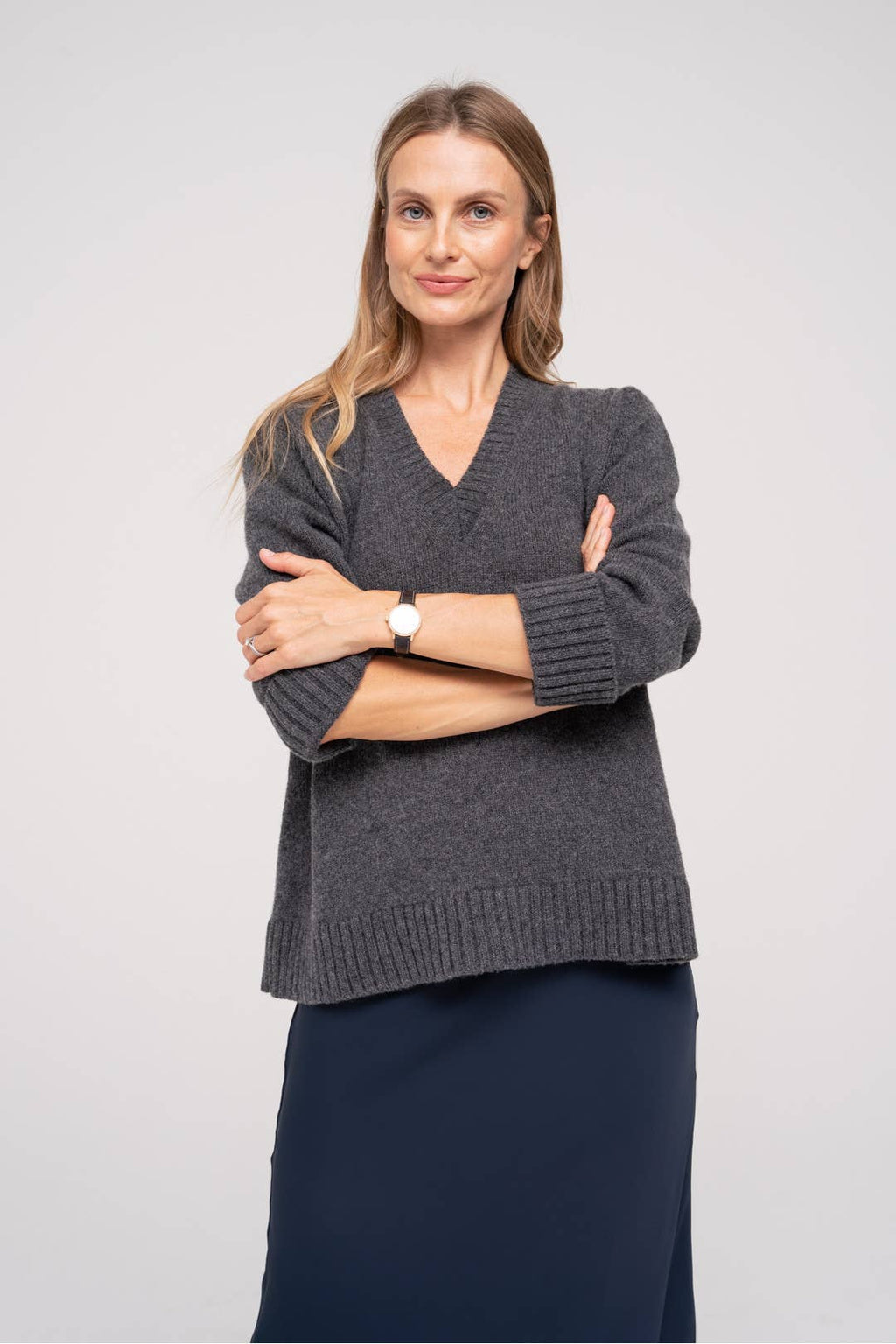 Rechtvallend grijs breiwerk. Nadruk ligt op de normale lengte en veelzijdigheidvan de trui.